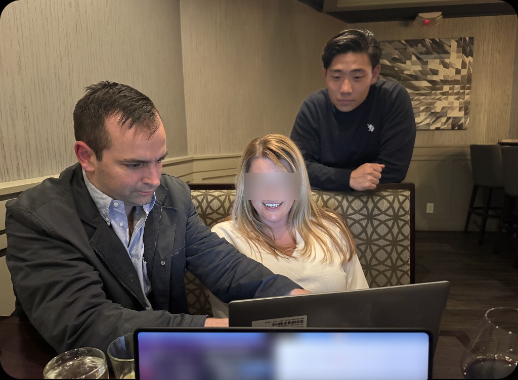 Three people collaborating on a laptop